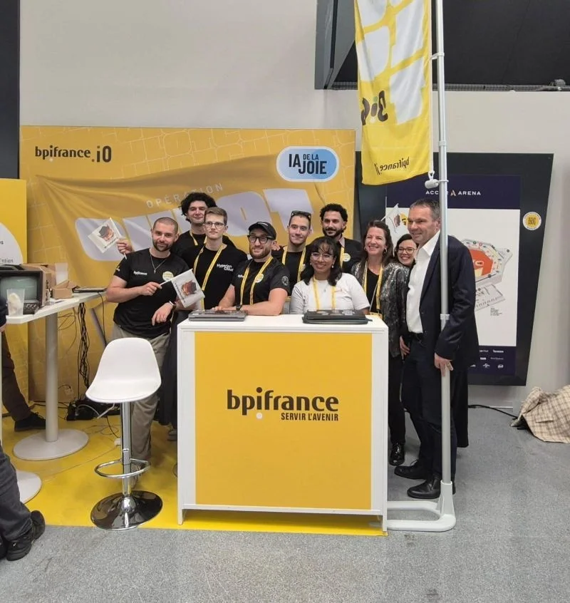 Sur le stand « Opération Culot » de Bpifrance à BIG 2026, à l'Accor Arena, l'équipe Hack'Olyte, le CEO d'Hyperion Cloud et des responsables de Bpifrance posent derrière le comptoir.